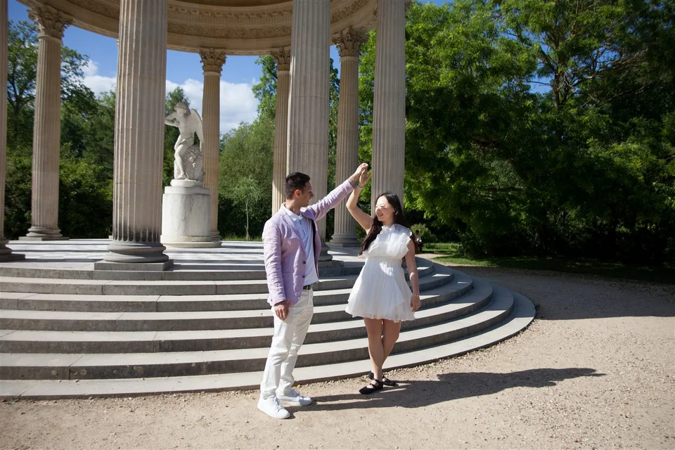 Alex and Yashi dancing beside a garden pavilion